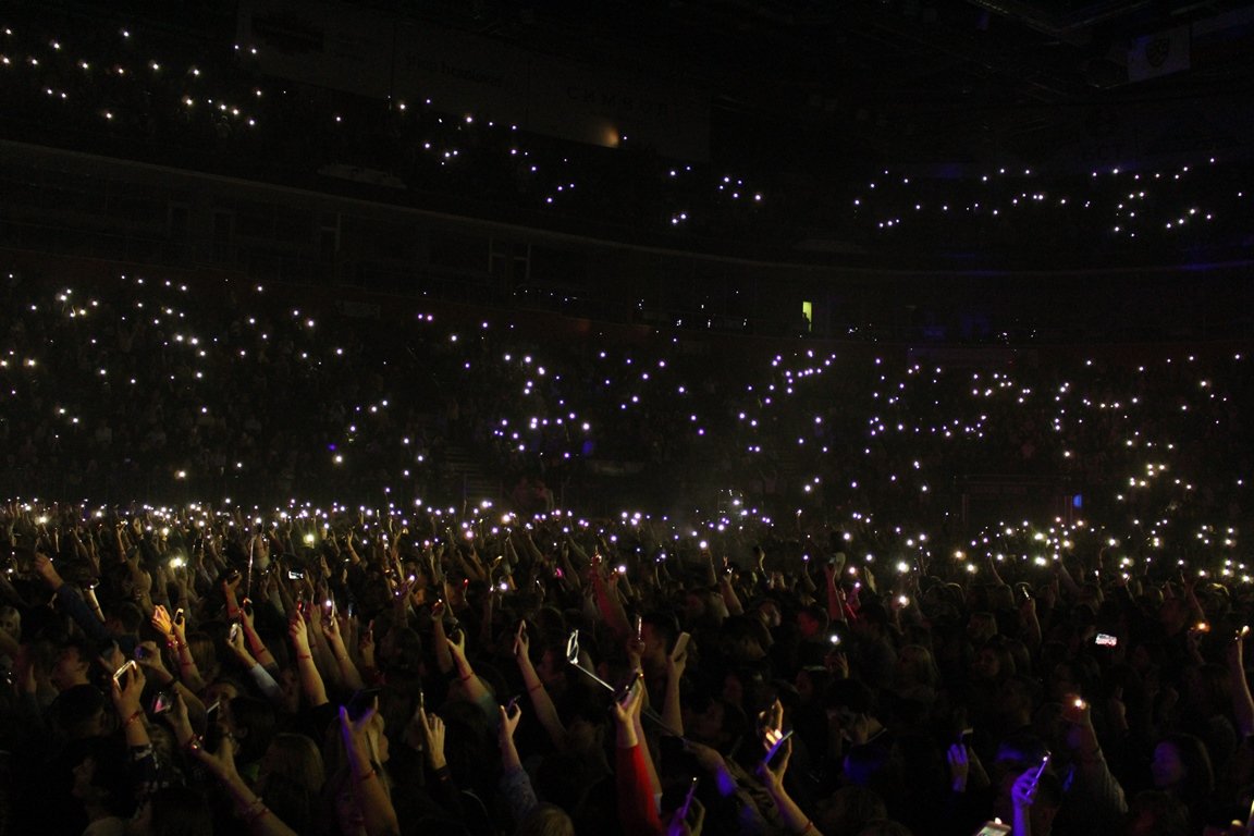 Много людей на концерте. Фонарики на концерте. Концертный зал с фонариками. Зрители с фонариками. Зал со зрителями.